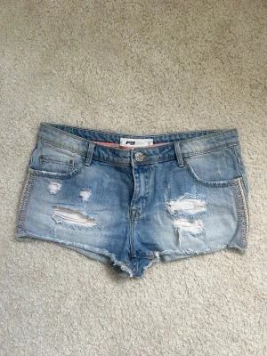 Lågmidjade jeans shorts  - Jätte snygga och jätte lågmidjade shorts med rosa broderier på sidan💕aldrig använda av mig, köpt begagnat här på plick för 450kr🤗