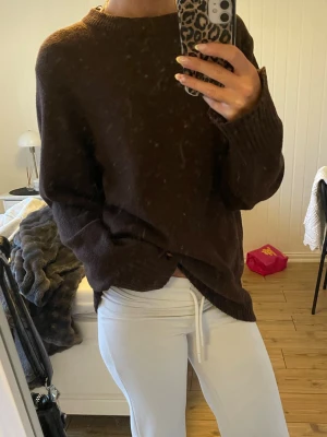 Mörkbrun stickad tröja - Mysig mörkbrun stickad tröja med rund halsringning. Tröjan har långa ärmar och ribbade muddar vid ärmslut och nederkant. Tröjan är i storlek S.