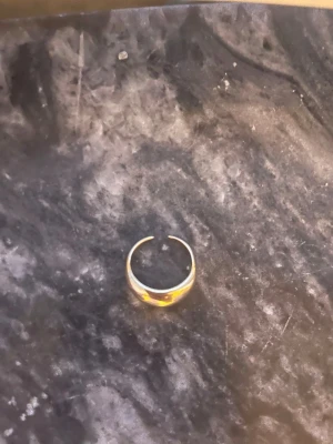 Tjock guldfärgad öppen ring - Säljer en stilren och chunky guldfärgad ring med öppen design. Ringen har en rundad, bred form som ger ett trendigt och modernt intryck. Perfekt för dig som gillar minimalistiska accessoarer med lite extra attityd.