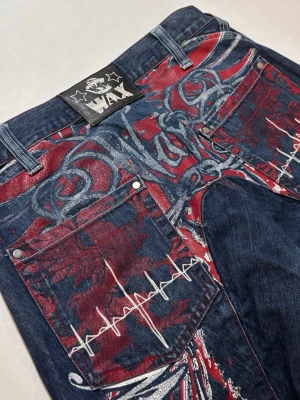 Wax Jeans - Blå Wax Actionwear jeans med ”La Famiglia” ”Famiglia Wax” tryckt bak på benen.  Slitage höger ben baksida, början till ett hål men inte riktigt igenom. Går lätt sätta en patch över. I övrigt gott använt skick. Se bilder för att själv bedöma.  Skicka ett meddelande om du har frågor eller vill se fler bilder 