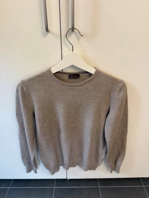 Beige stickad tröja från Stenströms i Merinoull, stl XL men sitter som XS - Säljer en stilren beige stickad tröja från Stenströms i storlek XL men sitter som XS. Tröjan har rund halsringning, långa ärmar och ribbade muddar vid ärmslut och nederkant. Perfekt för dig som gillar klassisk och enkel stil.
