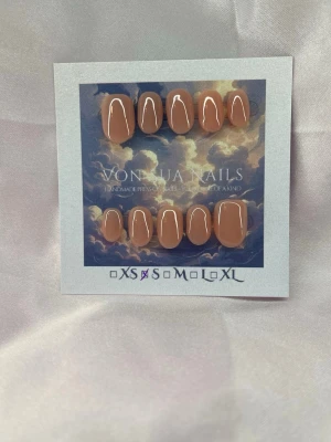 Silk (S);ExtraShortOval  - Snygga handgjorda press-on naglar i en nude färg med glansig finish. Naglarna har en extra kort oval form och kommer i  S: 15 mm, 11,5 mm, 12 mm, 11 mm, 9 mm. Perfekt för dig som vill ha en clean och stilren look på naglarna.