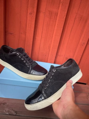 Svarta sneakers med mocka och lackdetalj - Hej säljer dessa fräscha lanvins  Storlek:9= 43 Skick:8/10  Färg:svart  Hör av dig vid frågor eller för fler bilder