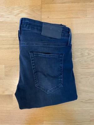 Svarta slim fit Jack and Jones jeans - Riktig schysst Jack and Jones jeans i modellen slim fit och har en riktigt bra passform. De är svarta med gråa fräscha slitningar i st 30L 30W