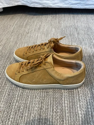 Beige mockasneakers med vit sula - Snygga sneakers i beige mocka med matchande skosnören och vit gummisula. Låg modell från H&M med rund tå och diskret design som passar till det mesta. Skorna har en mjuk insida och stilrena detaljer för en clean look.