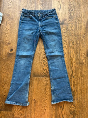 Blå bootcut jeans  - Ett par blåa bootcut jeans från Kappahl! De är väl använda och har blivit slitna längst ner i benen. Storlek 38 