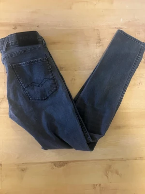 Blå jeans från Replay - Snygga blå jeans från Replay med klassisk femficksdesign och mörk tvätt. Jeansen har raka ben och tydliga sömmar på bakfickorna. Tillverkade i ett mjukt denimtyg som sitter skönt hela dagen.