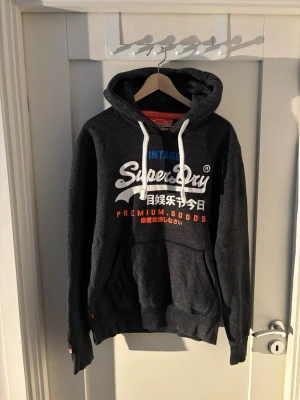 Superdry hoodie - Grå superdry hoodie size M väldigt bra skick ända defekten är att trycket är lite använt men det är normalt med dessa hoodies och det sker naturligt 