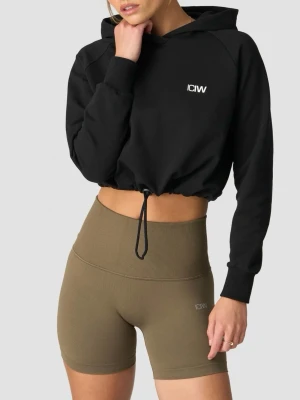 Svart cropped hoodie från ICANIWILL - Säljer en svart cropped hoodie från ICANIWILL med justerbar dragsko i nederkanten och liten vit logga på bröstet.