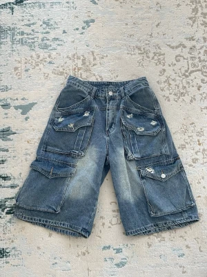 Baggy cargoshorts - Jorts i cargostil i blå denim. Passar storlek XS-S beroende på vilken passform man vill ha