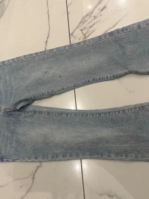 Ljusblå jeans - Säljer ett par ljusblå jeans med rak passform och klassisk femficksdesign. Jeansen har en tidlös look med normalhög midja och är tillverkade i denim. Perfekta för en avslappnad och trendig stil.