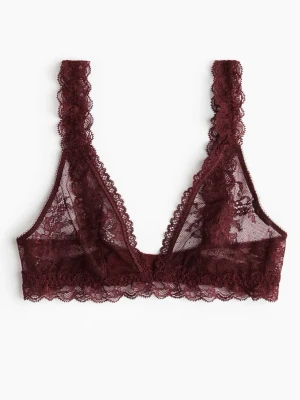 Vinröd spetsbralette med blommönster - Säljer en vinröd bralette i transparent spets med vackert blommönster. Bh:n har breda axelband i spets och mjuk, bygellös design för extra komfort. Perfekt för dig som gillar en feminin och stilren look. Aldrig använd då den inte passar! 