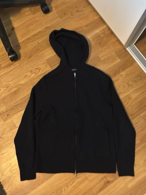 Mörk blå  zip hoodie med huva - En enkel och stilren mörk blå hoodie med dragkedja framtill och två fickor. Hoodien har en klassisk huva och långa ärmar. Perfekt för en avslappnad look och funkar året runt. Materialet ser ut att vara mjukt och bekvämt. M men sitter som xs/s