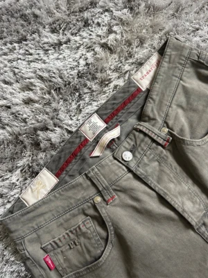 Schysst par gråa Tramarossa jeans - Snygga gråa jeans från Tramarossa med en stilren och exklusiv känsla. Modellen har raka ben, klassisk femficksdesign och snygga röda detaljer vid fickor och linning som ger en unik touch.  Nypris ligger runt 3 000 kr, säljes nu för endast 499 kr.🌟