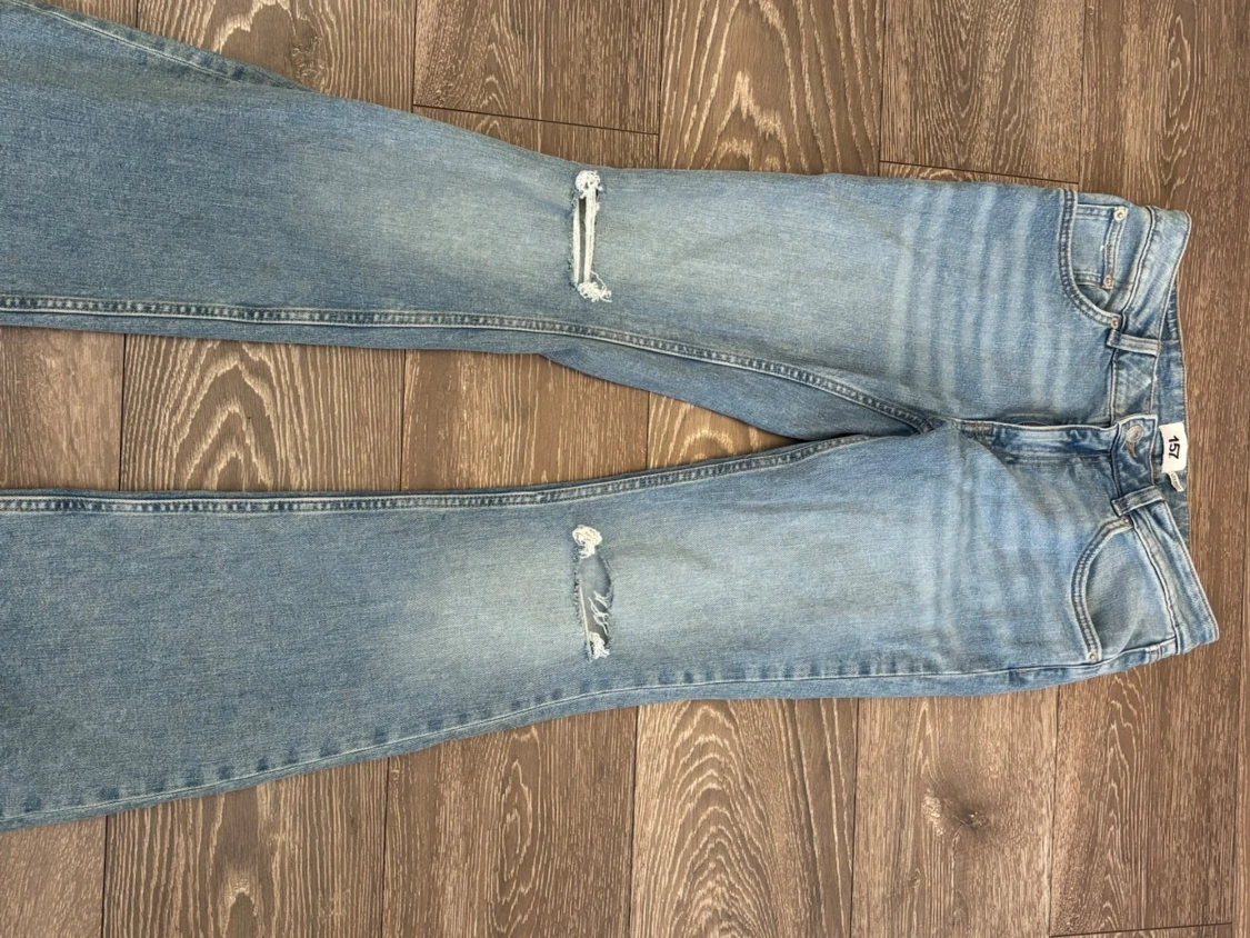 Ljusblå slitna bootcut jeans