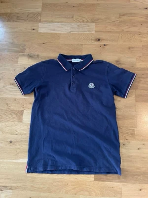 Moncler piké - Säljer en moncler piké i marin blå | storlek M men sitter lite mer som S | den är i fint skick | kom dm vid frågor!