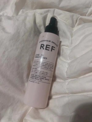 REF Leave In Conditioner spray - REF Leave In Conditioner är en vårdande spray från Stockholm Sweden i en ljusrosa plastflaska med svart spraymunstycke. Innehåller quinoa-protein och marulaolja, är vegansk och cruelty free. Perfekt för att återfukta och skydda håret. 1/4 är kvar i flaskan.