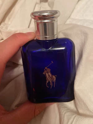 Polo Ralph Lauren Blue EDT. Kom med bud. Jag kan sänka pris!!  - Jag kan diskutera priset. Kom med förslag så löser vi nåt fint pris tillsammans:). Detta är en elegant parfym från Ralph Lauren, Polo Blue, i en djupblå glasflaska med silverfärgat lock och klassisk logga. Förpackningen är också blå med silverdetaljer och innehåller 75 ml Eau de Toilette. Perfekt för dig som gillar fräscha och maskulina dofter.