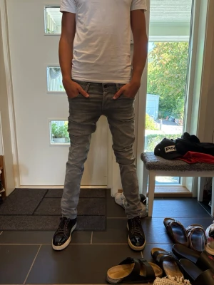 Gråa slim fit jeans herr - Säljer ett par gråa slim fit jeans med klassisk femficksmodell och normal midja. Jeansen har en snygg tvättad look och smal passform som sitter tight hela vägen ner. Perfekta för dig som gillar en modern och stilren stil. W 30 L 34