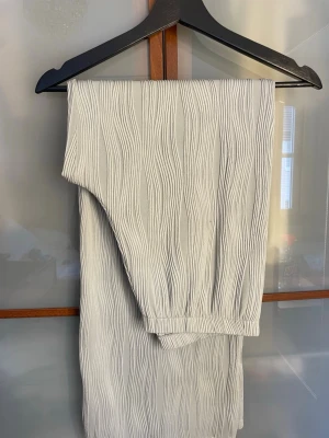 Gröna ribbade byxor med struktur - Snygga gröna byxor med unik ribbad struktur och vågiga linjer längs hela byxan. Mjukt och stretchigt material som sitter skönt på kroppen. Perfekta för dig som vill ha något stilrent men ändå med en cool twist.
