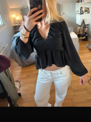 Svart volangblus med v-ringning - Snygg svart blus med djup v-ringning och volang nedtill. I storlek S från H&M!☺️☺️