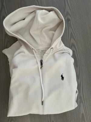 Vit hoodie från Polo Ralph Lauren - Snygg vit hoodie med dragkedja från Polo Ralph Lauren. Storlek S