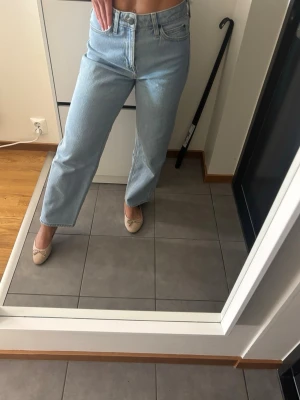 Ljusblå raka jeans från Lee - Säljer ett par ljusblå jeans med rak passform och hög midja. Jeansen har klassisk femficksdesign och stängs med dragkedja och knapp. Perfekta till en avslappnad och trendig look. Materialet är denim i bomull.