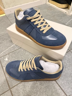 Blåa Maison Margielas  - Snygga blåa maison margielas som inte kommer till användning, den är helt oanvända och allting medföljer på bilderna. Skorna och lådan medföljs i köpet! Dem är i storlek 42 blå! Vid snabb affär kan vi diskutera priset