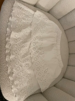 Vit broderad kjol från Zara - Supersöt vit kjol från Zara med broderade blommönster och volangkant. Kjolen har resår i midjan för skön passform och är gjord i ett lätt bomullstyg. Perfekt för en fräsch och somrig look!