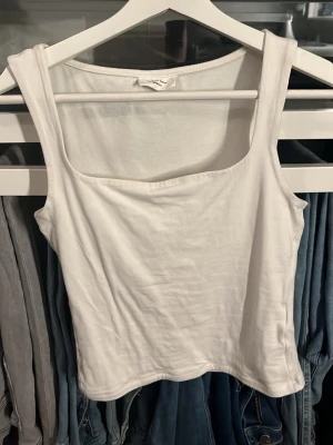 Vitt linne - Vitt linne med breda axelband från Gina tricot. 2 jätte jätte små fläckar bak som man ej tänker på