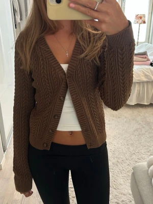 Brun stickad kofta Brandy Melville - Säljer en brun stickad kofta från Brandy Melville med knappar framtill. Passar en xs-s