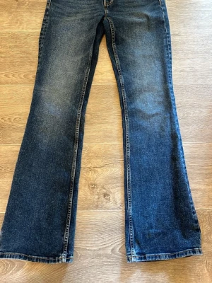 Mörkblå jeans från Lindex - Snygga mörkblå jeans från Lindex med klassisk femficksmodell och lite utsvängda nertill. Modellen heter Fay. Jeansen har bälteshällor i midjan och är lågmidjade. De är endast använda en gång så dom är i ny skick💗
