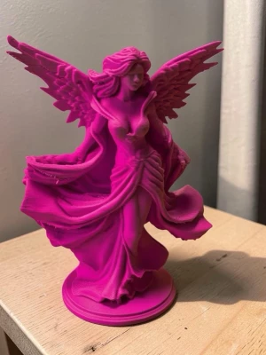 Rosa änglastaty i plast - Säljer en detaljerad änglastaty i starkt rosa plast. Figuren har stora vingar, långt vågigt hår och en svepande klänning. Perfekt som dekoration på hyllan eller skrivbordet för dig som gillar fantasy och unika prydnader.