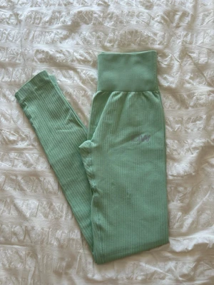 Ribbstickade mintgröna leggings från ICIW - Snygga ribbstickade leggings i mintgrönt med hög midja och bred resår. Materialet är stretchigt och mjukt, perfekt för en avslappnad look. Diskret logga på låret.