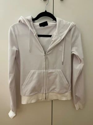 Juicy Couture tröja - En vit Juicy Couture tröja💕  Använd flertal gånger, har tappat ena metall detaljen som sitter på remmen (som är kopplad till luvan) men inga andra skador🫶🏼