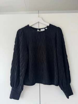 Svart långärmad blus från Vila - Säljer en fin svart blus med textur från Vila, i storlek S. Blusen är långärmad och har en avslappnad passform.  Den är använd några gånger, men är fortfarande i fint skick.💕