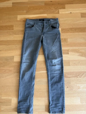 Gråa jeans från Replay - Snygga grå jeans från Replay med klassisk femficksdesign. Jeansen har smal passform hela vägen ner och är perfekta för en trendig och avslappnad look. Tillverkade i stretchigt denimtyg för extra komfort.