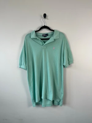 Vintage Polo Ralph Lauren Piké XL Mintgrön Ljusgrön 100% Bomull Herr - • Storlek: XL • Färg: Mintgrön • Passform: Classic Fit  • Krage: Klassisk pikékrage • Material: 100% bomull  Skick: Plagget är i väldigt fint skick. Eventuella anmärkningar anges alltid tydligt i beskrivningen och visas på bilderna.  Nypris: Cirka 1 400 kr.  📦 Skickas snabbt och packas omsorgsfullt. 💬 Hör gärna av dig om du har frågor eller vill se fler bilder. 🤝 Samfrakt erbjuds vid köp av flera plagg – kika gärna in mina andra annonser!• Storlek: XL • Färg: Mintgrön • Passform: Classic Fit  • 