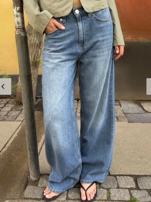 Nelly baggy jeans  - Säljer ett par blåa jeans med riktigt breda ben och hög midja. Jeansen har klassisk femficksmodell och stängs med knapp och dragkedja. Perfekta för en avslappnad och trendig look. Materialet är denim i bomull.