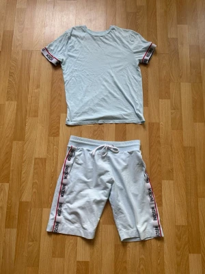 Moschino set med shorts och t-shirt - FRAKTAR SAMMA DAG  Dem är använda men har tagit hand om dem bra. Det finns inga hål, slitningar eller andra defekter
