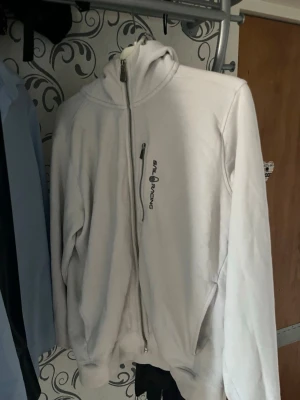 Sail Racing hoodie - Vit hoodie från Sail Racing med dragkedja. Har lite trasiga armar. Väldigt använd. 