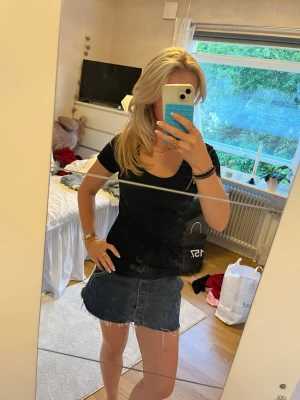 Svart basic t-shirt med U-ringning - En svart basic t-shirt med v-ringning och korta ärmar. T-shirten har en enkel och stilren design, perfekt att matcha med jeans eller kjol. Tillverkad i mjuk bomull för skön känsla hela dagen.
