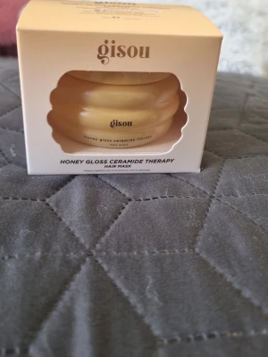 Gisou Honey Gloss Ceramide Therapy från sephora - Gisou Honey Gloss Ceramide Therapy Hair Mask i en söt burk som liknar en bikupa. Masken är guldfärgad och kommer i en vit förpackning. Perfekt för dig som vill boosta håret med glans och näring från honung och ceramider. Oanvänd  75ml