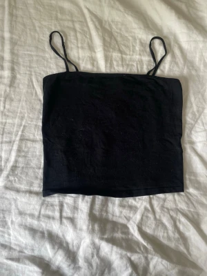 Svart  linnetopp - Det kommer från djurfrit hem. Ska visa magen.❤️En enkel svart linnetopp med smala axelband och rak skärning. Toppen är croppad och har en minimalistisk design som passar perfekt till jeans eller kjol. Tillverkad i mjukt material för en bekväm känsla.