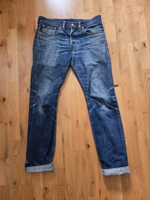 Dubble RL selvedge jeans  - Säljer ett par klassiska blå  dubble RL jeans med raka ben och uppvikta benslut. Jeansen har fem fickor, slitningar och en patch bak i midjan. Materialet är denim i 100% bomull och färgen är mörkblå med ljusare tvättade partier. Enda defekten är att fickorna är trasiga.