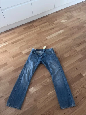 Blå raka jeans med klassisk passform - Levis 514 raka jeans. Unika slitningar som ser riktigt bra ut. Inga hål eller liknande slitage bara väl andvända.