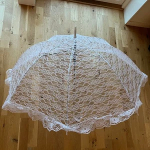Spets Paraply, spets handskar och spets strumpeband - Ett set bestående av ett vackert vitt spets paraply och ett par eleganta svarta handskar med rosetter och strumpeband. Romantiskt set som går perfekt att ha på ett bröllop eller vid något annat unikt tillfälle. Handtaget på paraplyet har dock lossnat men går att limma fast. 