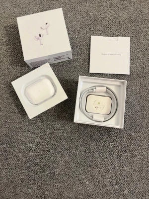 Apple AirPods Pro med laddningsetui - Säljer ett par vita Apple AirPods Pro med trådlöst laddningsetui. Hörlurarna har en stilren och kompakt design i blank plast och levereras i originalförpackning med laddningskabel och manual. Perfekta för dig som vill ha grymt ljud och smidig anslutning till din iPhone.