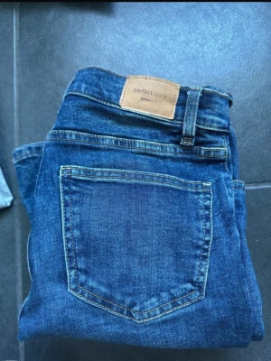Blå bootcut jeans  - Säljer ett par blå bootcut jeans från Gina Tricot med slitningar på låret och klassisk femficksmodell. Jeansens hål är gjorda själv💘
