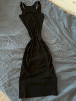 Svart långklänning - En svart långklänning med brottarrygg och figurnära passform. Klänningen är ärmlös och har en enkel design som passar perfekt till många olika tillfällen. Tillverkad i mjukt och stretchigt material för extra komfort. Kontakta mig om ni har några frågor💕